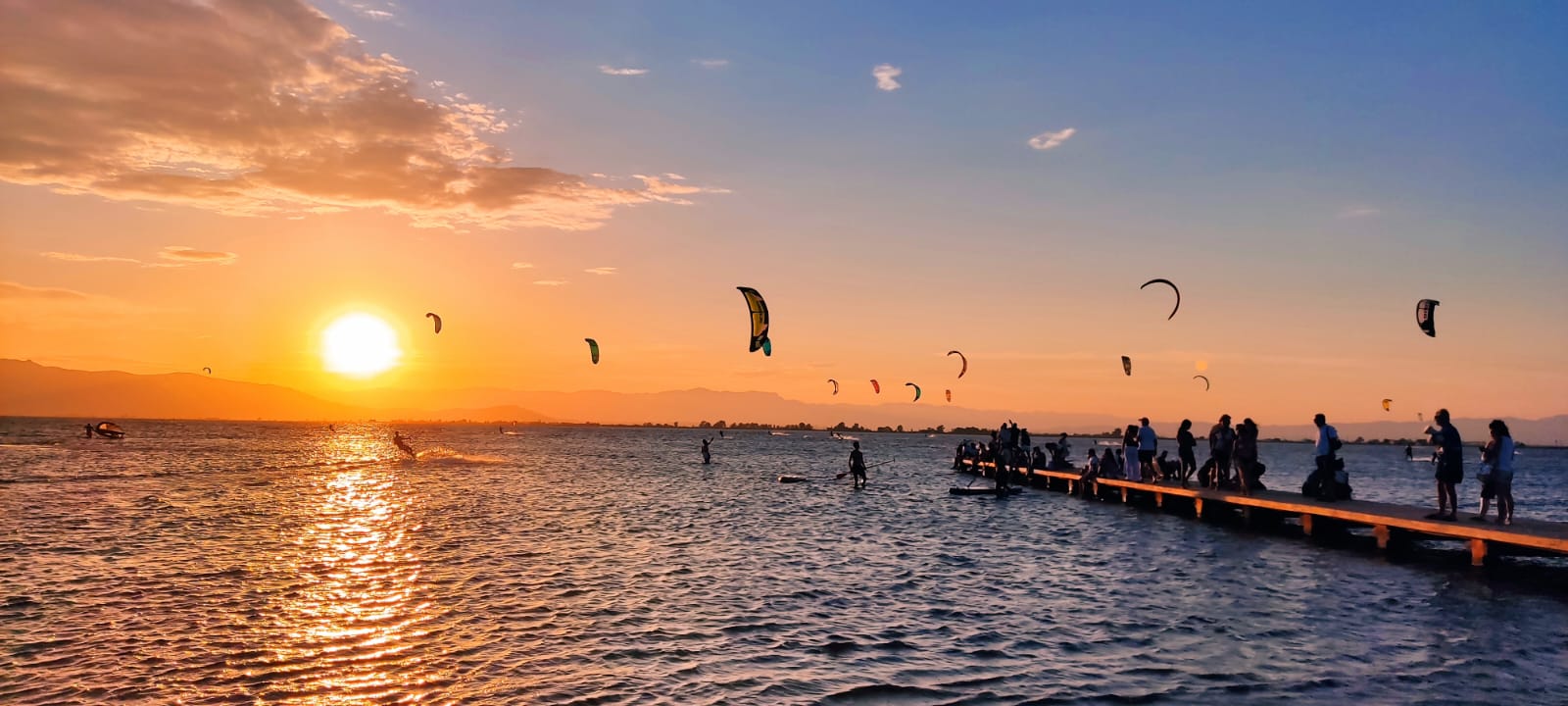 Dozens of kites at sunset over the bay